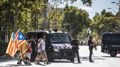 Un parell de furgons dels Mossos vigilen a la Gran Via la manifestació a Barcelona.
