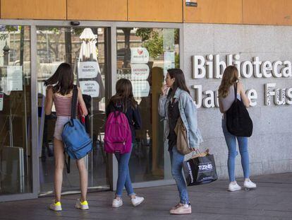 Jóvenes usuarios, el lunes, ante las puertas cerradas de la biblioteca Jaume Fuster de Barcelona.
