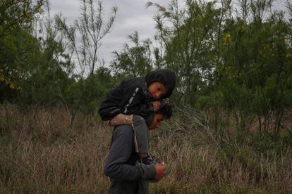 Ostavio, de 5 años, descansa sobre los hombros de su hermano Eduardo mientras caminan por un campo en Penitas (EE UU), el 31 de marzo de 2019. Ostavioy Eduardo son parte de los grupos que diariamente se arriesgan a cruzar ilegalmente el río Río Grande hacia los Estados Unidos desde México.