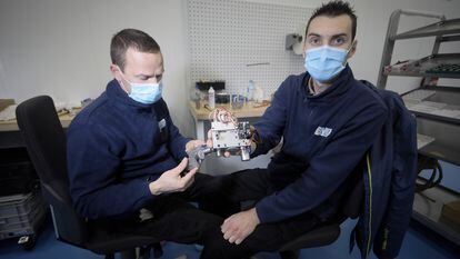 Óscar de la Cruz (izquierda) y Mario Ochescu, trabajadores de Escribano, muestran el corazón mecánico del respirador VITAE 40 en la fábrica de la empresa, en Alcalá de Henares (Madrid).