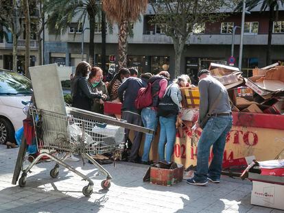 Ciudadanos recogen zapatos y otros objetos de un contenedor el pasado 6 de octubre en Barcelona.