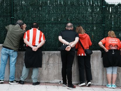 Unos aficionados observan desde una valla las instalaciones del Athletic de Bilbao, el viernes en Lezama (Bizkaia).