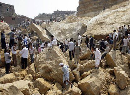 Decenas de personas tratan de buscar a supervivientes bajo las enormes piedras que se desprendieron de la ladera