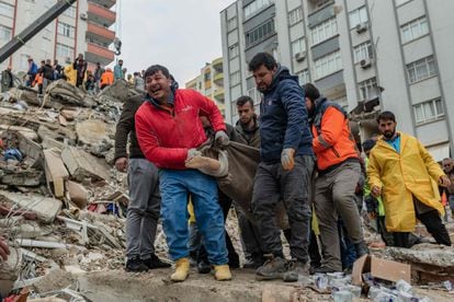 Los equipos de rescate sacan un cuerpo de entre los escombros de une edificio de Adana, Turquía.