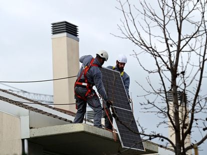 Dos empleados instalan un panel solar en una vivienda en Boadilla del Monte (Madrid).