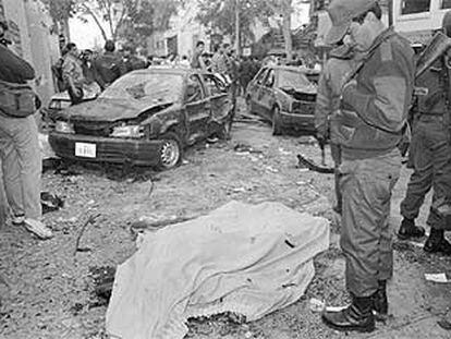 Un policía observa un cadáver tras un atentado de Sendero Luminoso en Lima en 1995.