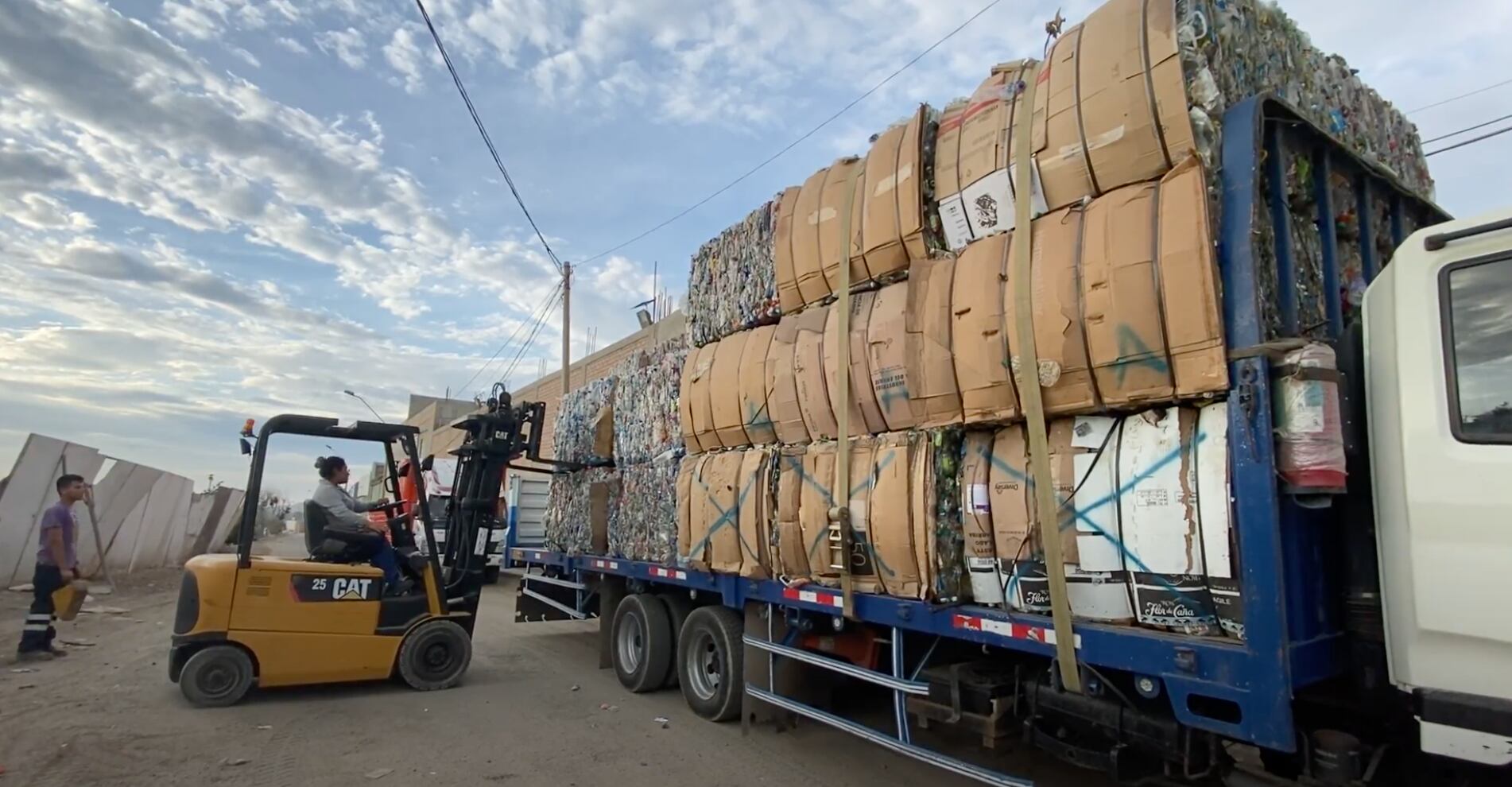 Empleados de Sinba descargan desechos plásticos de un camión para iniciar su proceso de recuperación y reutilización.