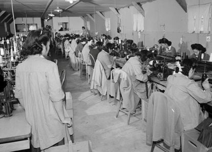 La mayoría de los adultos trabajaba y percibía un pequeño sueldo, con el que podía comprar cosas por catálogo. En la imagen, una supervisora controla la producción de las mujeres que trabajan con las máquinas de coser del Centro de Reubicación de Guerra 'Manzanar', en 1943 en California.