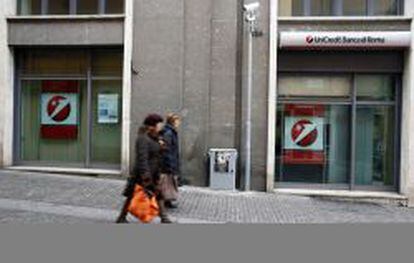 Dos transeuntes pasan delante de una sucursal de Unicredit en Viterbo, Italia. El primer grupo bancario del pa&iacute;s est&aacute; registrando las mayores ca&iacute;das burs&aacute;tiles de la zona euro tras el rescate a Chipre.