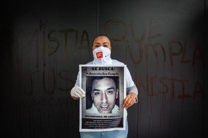 Alicia Reyes, madre de Antonio Candelaria, posa con un cartel de su hijo en una protesta por la ley de amnistía.