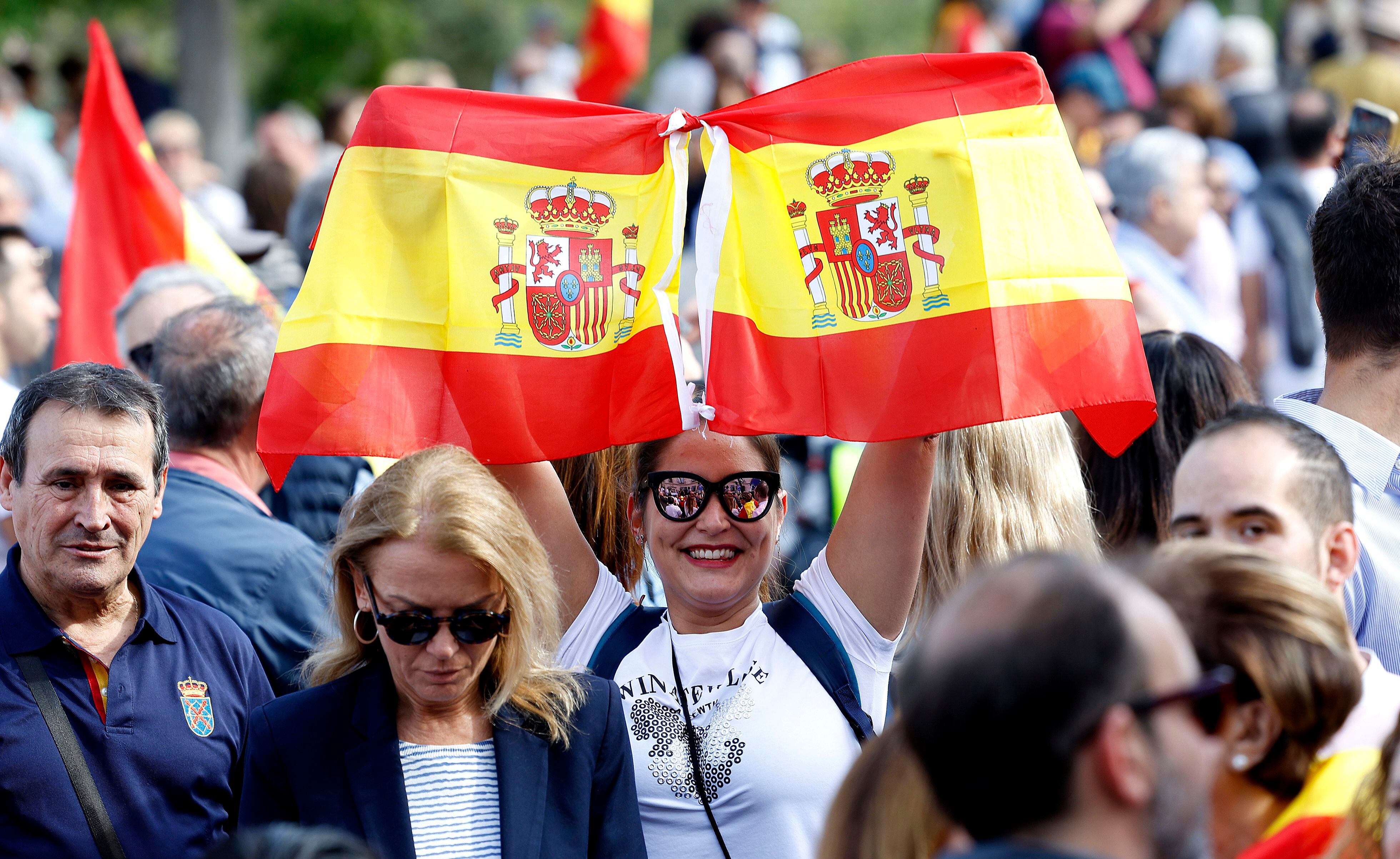 Una manifestante mostraba dos banderas de España durante la concentración convocada por el Partido Popular en la plaza del Temple de Valencia.