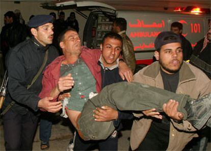 Dos palestinos evacúan a un hombre herido en el campo de refugiados de Rafah.