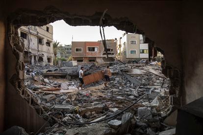 Dos palestinos inspeccionan su casa, atacada por un ataque aéreo israelí, en Gaza.
