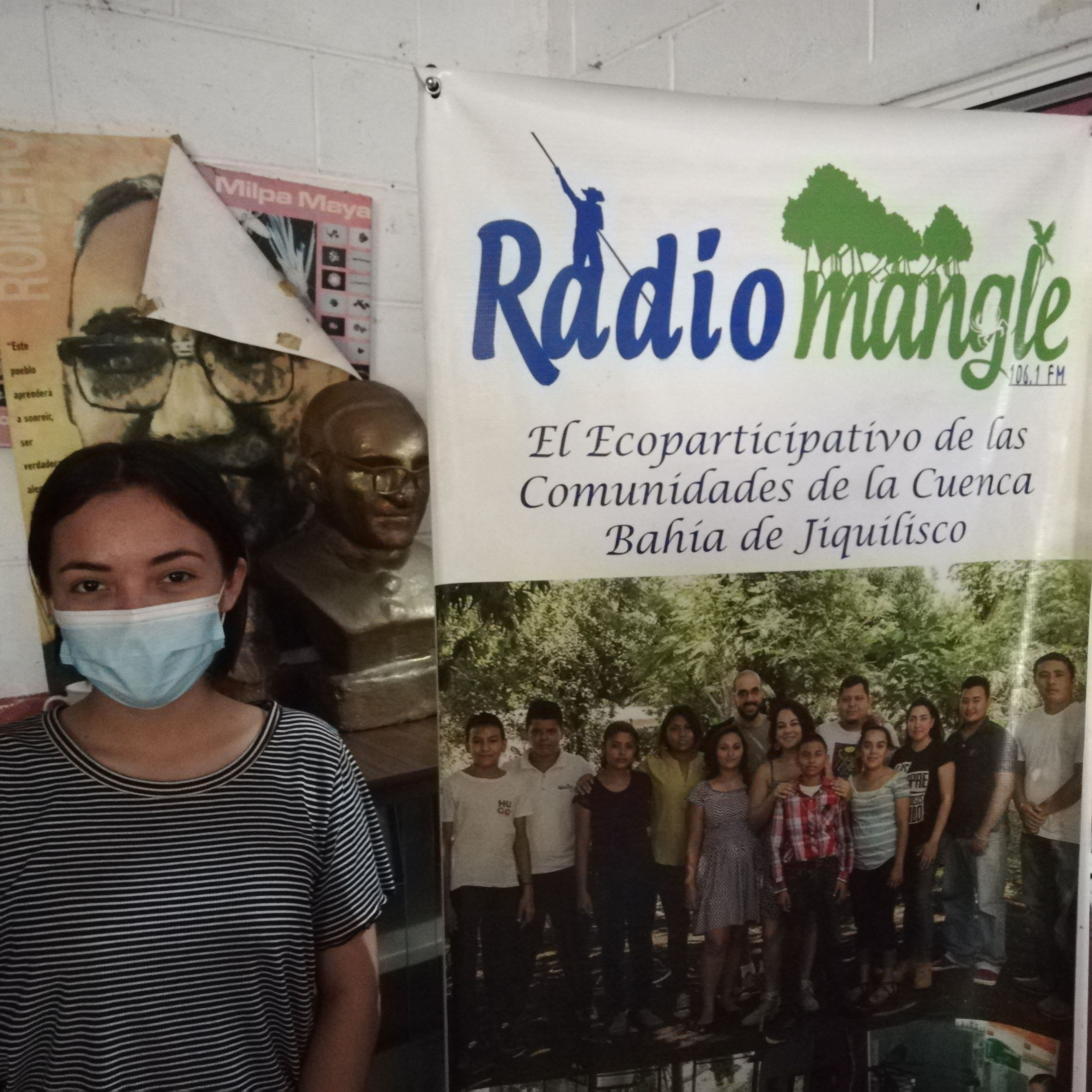 Wendy Hernández explica frente a un busto del Padre Romero que la radio sirve como instrumento en la comunidad para denunciar crímenes ambientales, como el robo de tierras.
