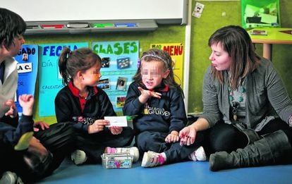 Una niña explica con lenguaje de signos la palabra escrita en el papel.