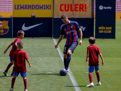 Lewandowski juega con unos niños durante su presentación en el Camp Nou.
