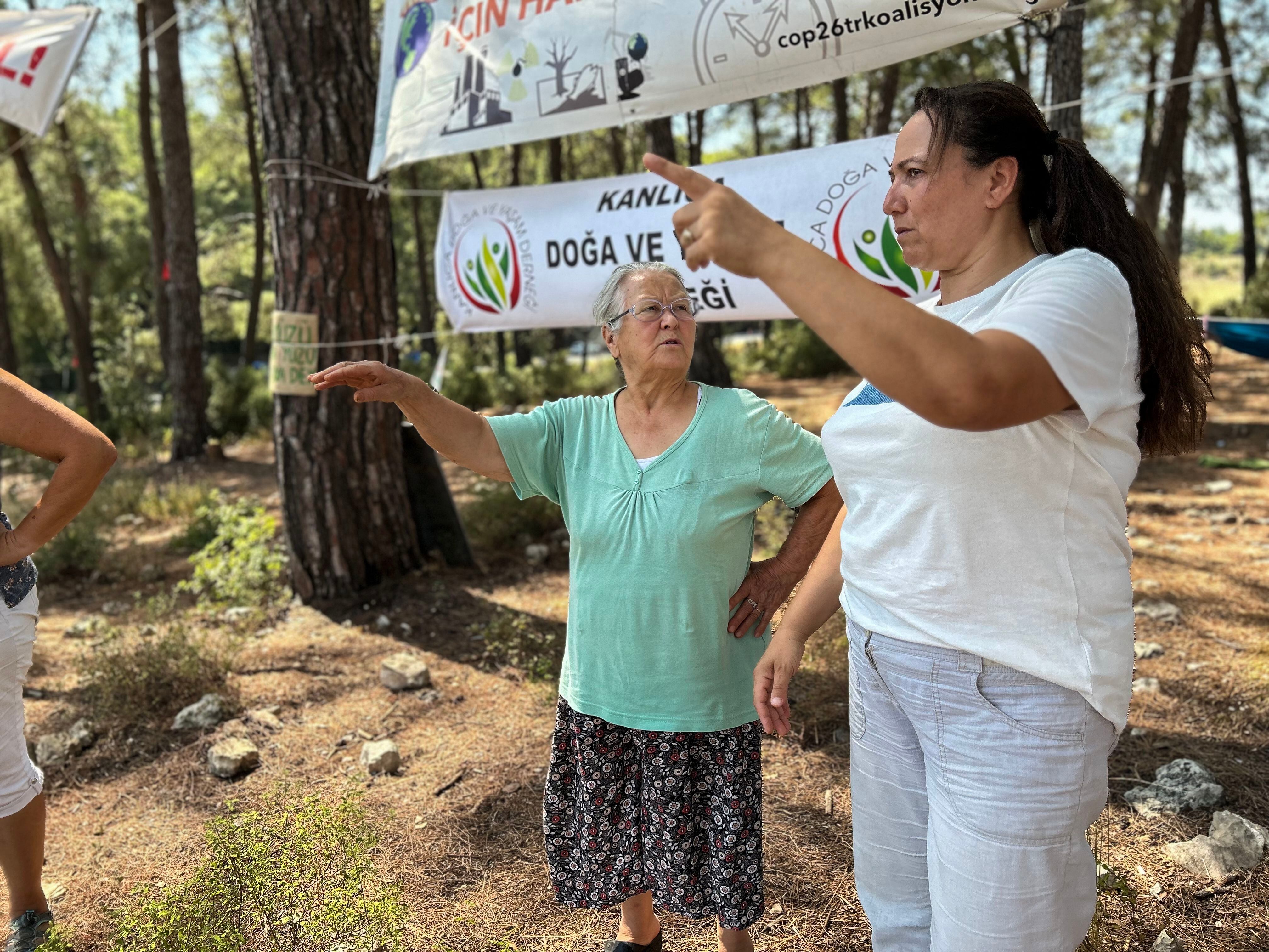 Naime Yorulmaz (izq) y Nejla Isik, dos habitantes de la aldea de Ikizköy (sudoeste de Turquía), señalan a los árboles talados para ampliar una mina de lignito que gestiona la empresa que construirá el nuevo estadio del Barça.
