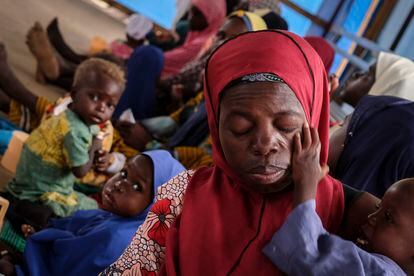 Una madre agotada es consolada por su hijo en el centro de educación nutricional para casos moderados de Aguié. Al fondo, el cabello de otro niño se ha aclarado, un síntoma habitual de la malnutrición.