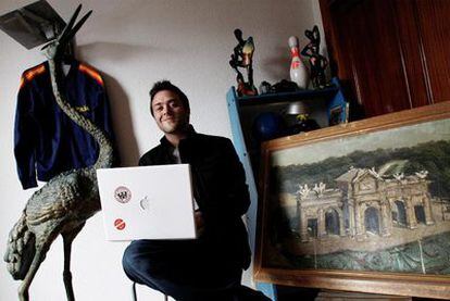 Alejandro Biehler posa en su casa de Madrid junto con los objetos que ha puesto a la venta por eBay para costearse las vacaciones.