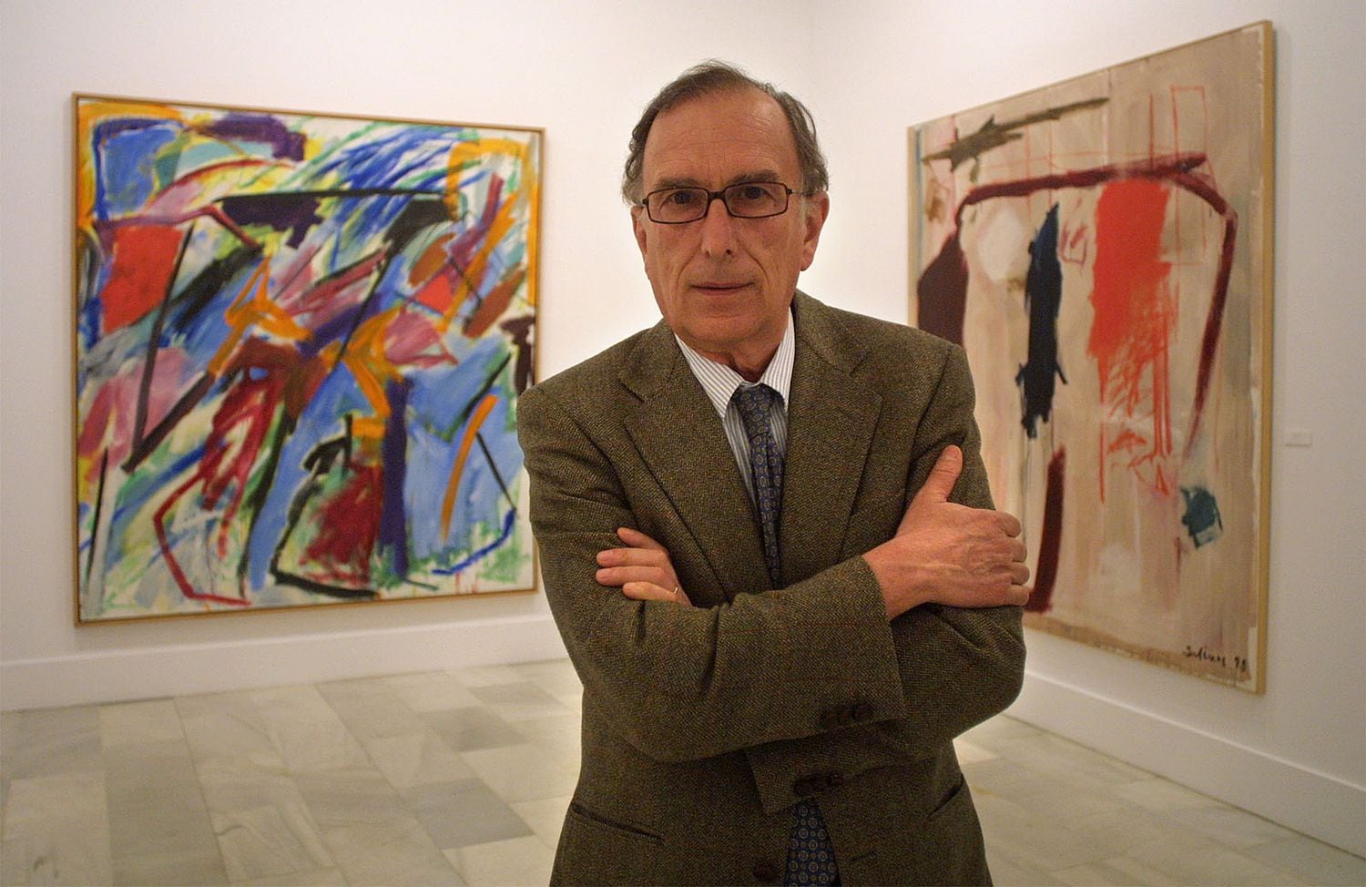 El pintor abstracto Manuel Salinas posa ante dos de sus pinturas en la exposición sobre su obra en la sala Chicarreros de Sevilla, en 2003.