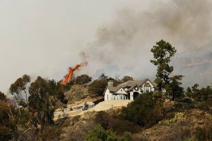 Las llamas se aproximan a un casa situada en el monte San Gabriel en Glendora, a unos 40 kilómetro de Los Ángeles (EE UU).