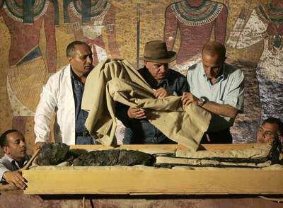Zahi Hawass, con sombrero, ayer en el momento de trasladar a Tutankamón desde el sarcófago a la nueva urna de exhibición.