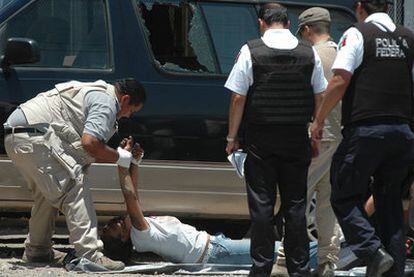 Un forense retira el cadáver de uno de los ocho muertos en un ataque a una clínica de desintoxicación en Ciudad Juárez.