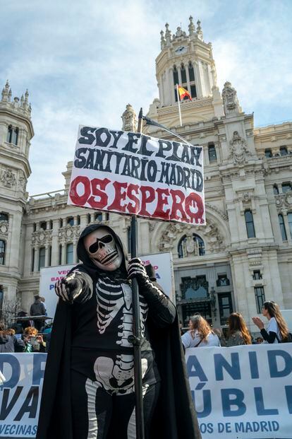 Un manifestante disfrazado porta una cartel con el lema "Soy el plan sanitario" frente a la fachada del Ayuntamiento de Madrid.