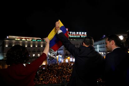 La presidenta de Madrid, Isabel Díaz Ayuso, y el líder venezolano Juan Guaidó, sostienen una bandera de Venezuela ante cientos de personas en la Puerta del Sol, acompañados por el entonces vicepresidente Ignacio Aguado.