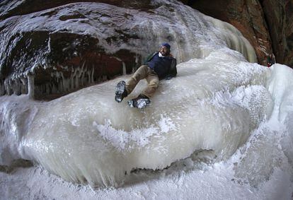 El hombre se desliza por la pared de hielo cerca de las cuevas de las Islas Apostle.