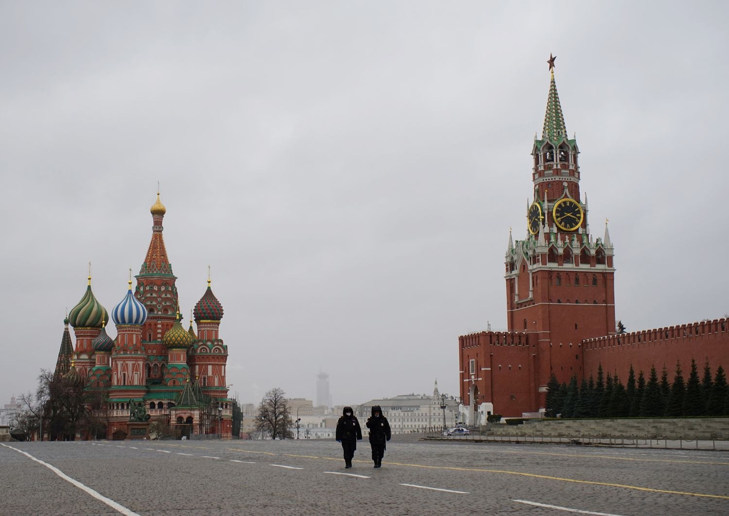 Dos policías caminan por la plaza Roja de Moscú, frente a la catedral de San Basilio y el Kremlin, este lunes, primer día de cuarentena en la capital rusa.