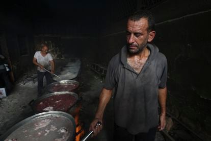Dos palestinos preparaban comida este sábado para los desplazados en Rafah, durante el actual bombardeo israelí sobre la Franja.
