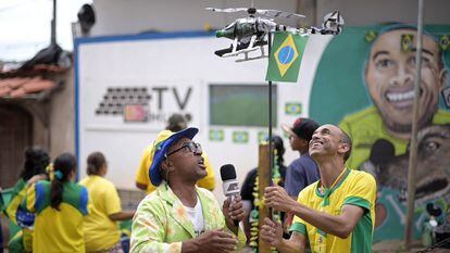 Repórter Salada (izquierda) y Chiquinho (derecha) usan su dron improvisado durante el partido entre Brasil y Corea en la Copa del Mundo 2022.