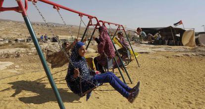 Unos niños palestinos se columpian en Susya el martes.