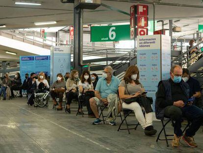 Decenas de personas entre 55 y 59 años hacen cola para vacunarse en el centro de vacunación de la Fira de Barcelona.