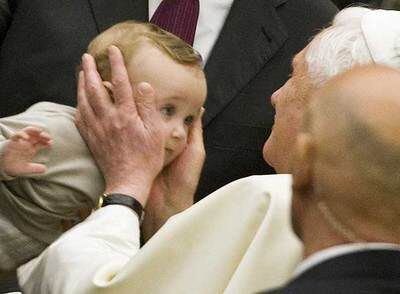 El papa Benedicto XVI acaricia a un bebé el miércoles durante su audiencia general en el Vaticano.