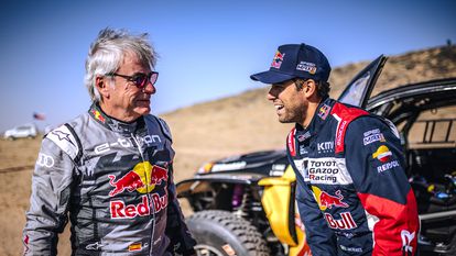 El piloto español Carlos Sainz junto al brasileño Lucas Moraes, antes del comienzo de la tercera etapa del Dakar.