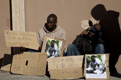 Un grupo de subsaharianos exhibe fotos del senegal&eacute;s muerto y muestra carteles reclamando justicia en el lugar en que se cometi&oacute; el crimen.