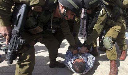 Soldados israel&iacute;es detienen a un manifestantes en Hebr&oacute;n, el viernes.