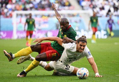 Christian Bassogog, de Camerún, lucha por la posesión del balón contra Srdjan Babic, de Serbia, durante el partido de este lunes disputado en el estadio Al Janoub.