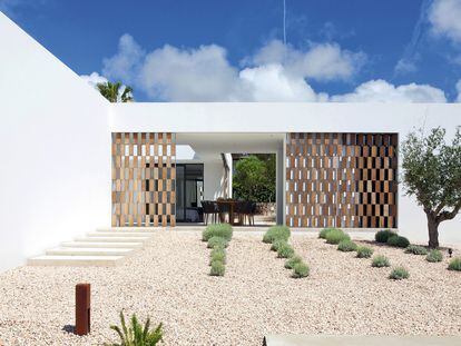La entrada a la casa se ha diseñado con grava formada a partir de piedras de marés (un tipo de arenisca autóctona de las islas Baleares) y vegetación local como el romero, el jazmín y el olivo.