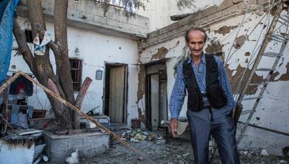 Un miembro de las fuerzas de seguridad kurdas inspecciona una casa bombardeada, este martes en Qamishli.