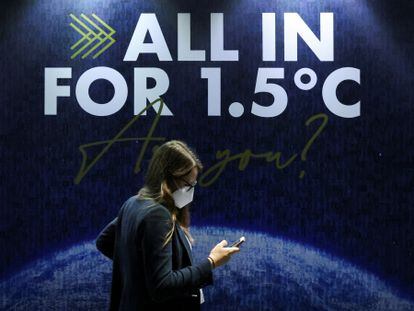 Una delegada pasa junto a un letrero durante la COP26 en Glasgow.