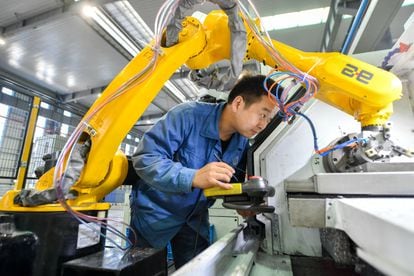 A technician works with robots at a smart factory in Zhejiang, China, in October 2020.