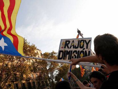 Un hombre sostiene una estelada junto a una pancarta de &quot;Rajoy dimisi&oacute;n&quot; durante la huelga general en Barcelona. 