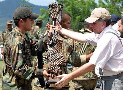 Un paramilitar entrega su arma y munición al negociador gubernamental Luis Carlos Restrepo en la provincia del Valle en 2004.