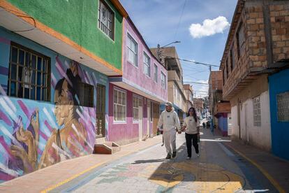 May Rojas and Luisa Sabogal walk down a street in Ciudad Bolívar.