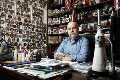 El médico Jorge Cartes, junto a su colección de emblemas en su casa de Madrid.