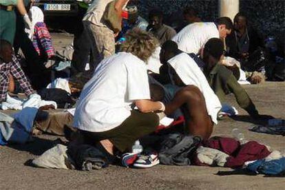 Personal sanitario atiende a uno de los 43 inmigrantes que llegaron el día 4 al muelle de La Restinga, en El Hierro.