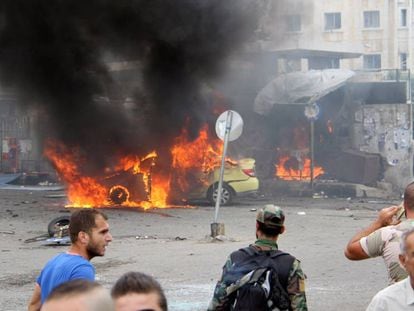 Un soldado sirio y civiles este lunes tras las explosiones que golpearon la ciudad siria de Tartous.